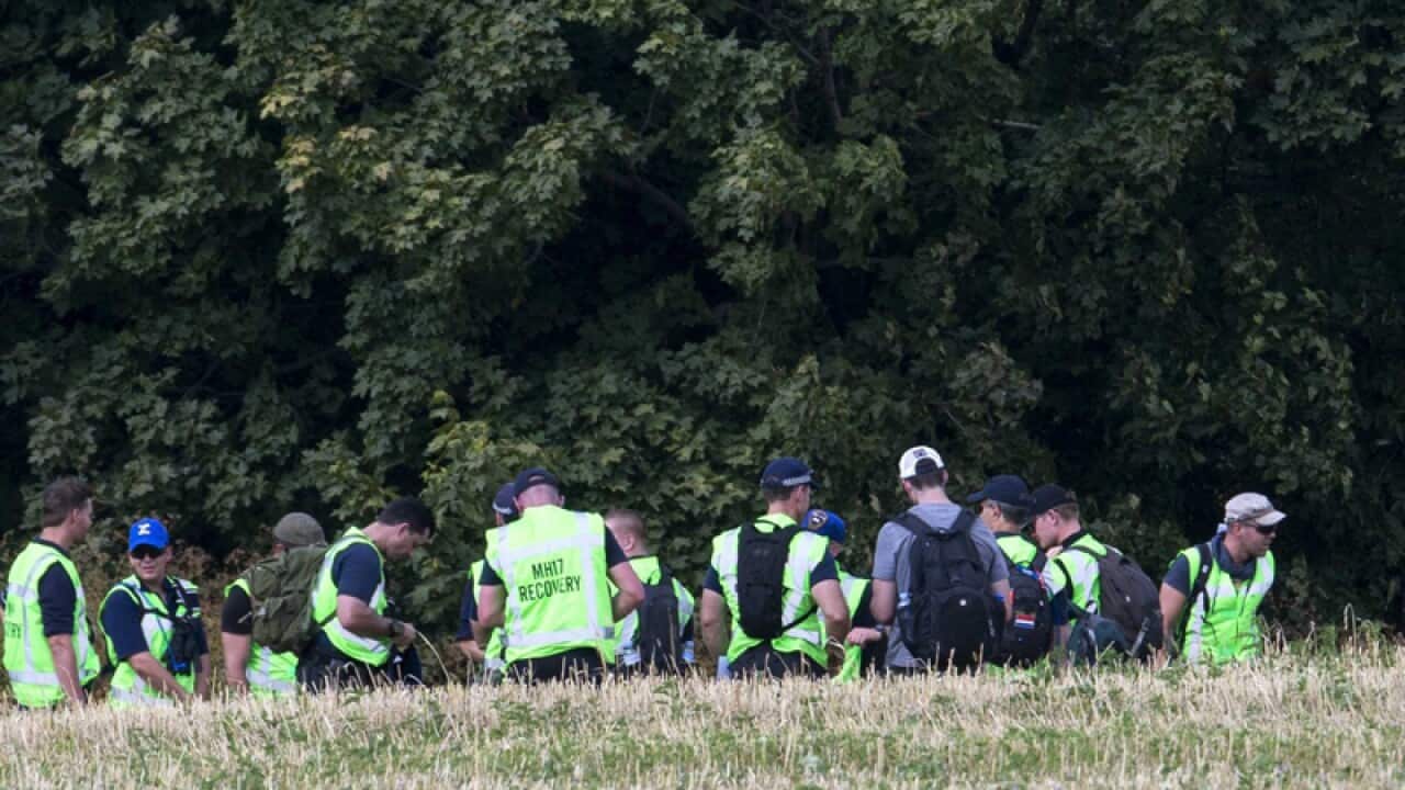 Investigators examine the plane crash site of MH17 in the Ukraine.