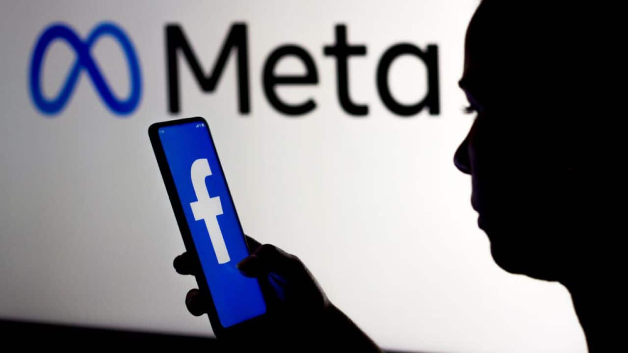 In this photo illustration, a woman holds a smartphone with Facebook and Meta logos.