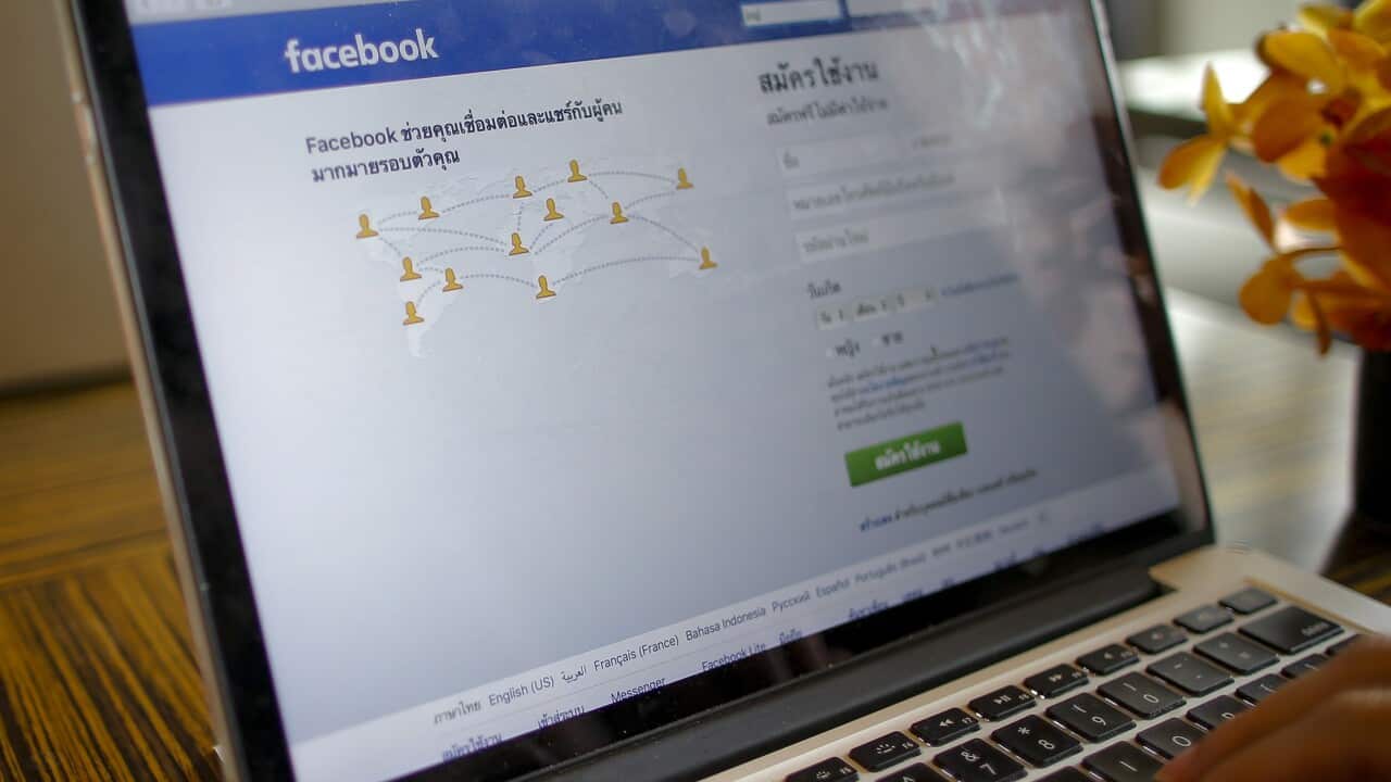 A person uses a computer displaying the Thai Facebook login page in Bangkok, Thailand