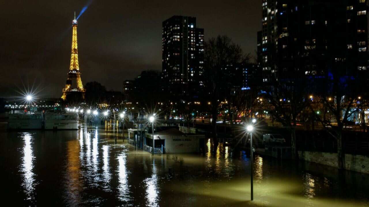 A picture taken late on January 28, 2018 in Paris shows the flooded Quai de Grenelle by the banks of the Seine river, with the Eiffel Tower in background.