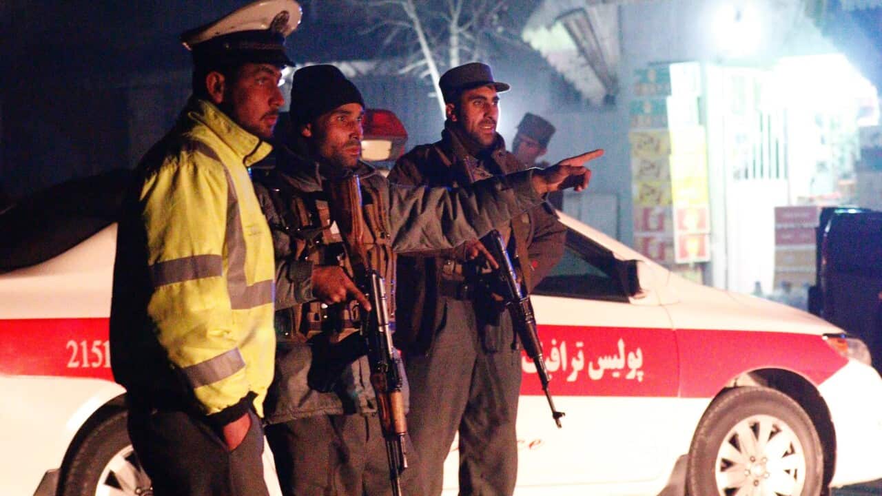 Afghan security officials secure the scene of a suicide bomb attack that targeted a French restaurant Le Jardin, in Kabul
