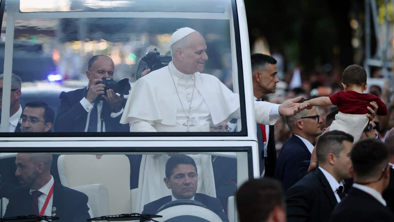 Pope Leo XIV extends his hand to a toddler