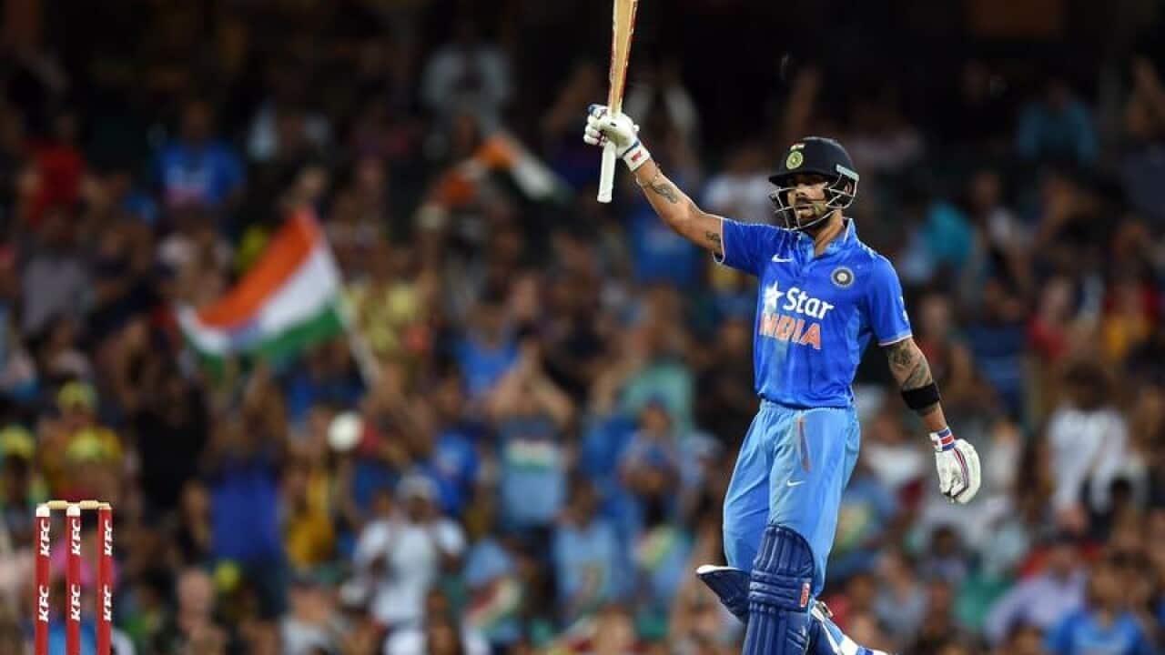 Virat Kohli holds up his bat