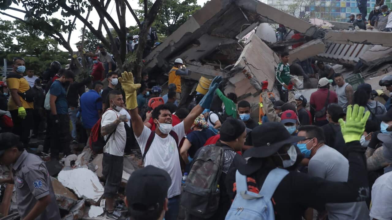 Rescue workers operate at the site of a collapsed building following an earthquake in Cali, Colombia (AAP)