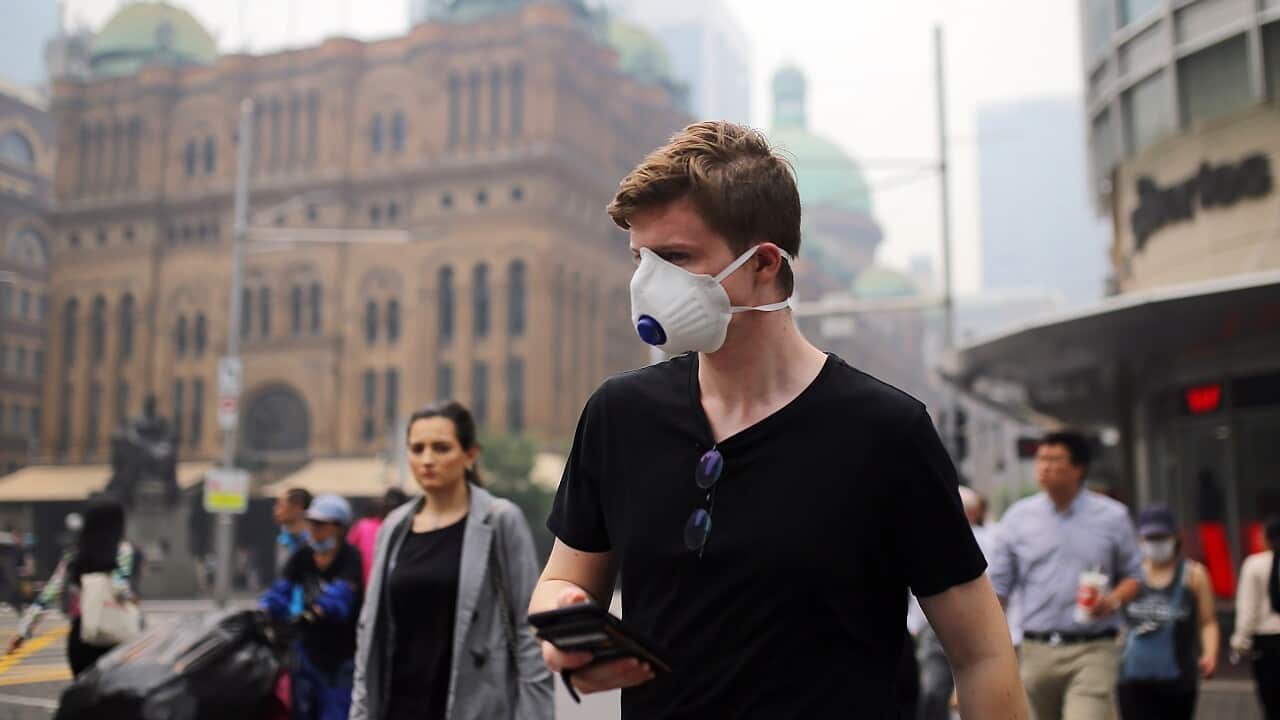 Pedestrians wear masks as smoke haze from bushfires hits Sydney.