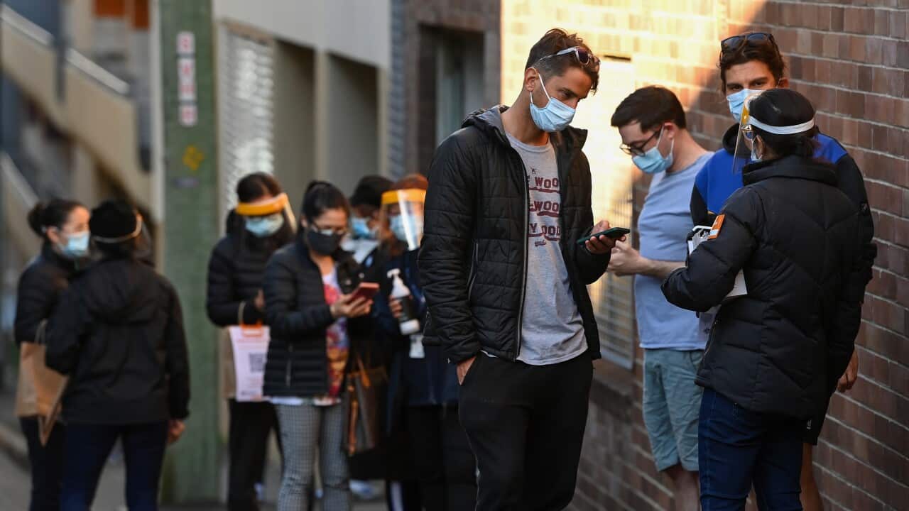 People wearing face masks line up for their COVID-19 vaccination at the NSW Health Walk-in AstraZeneca vaccination clinic in Glebe, Sydney, Sat, Aug 7, 2021.
