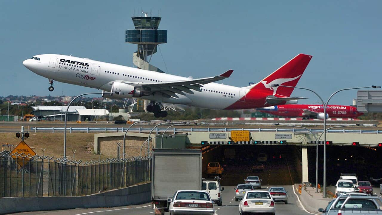A Qantas Airlines passenger jet takes off over local traffic