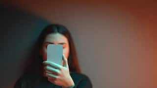 Girl blocks face with phone