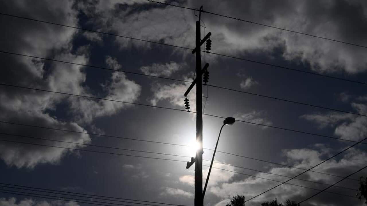 The sun is seen behind a telegraph pole