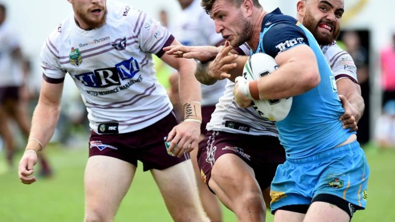 Jai Arrow of the Gold Coast takled by Dylan Walker of Manly.