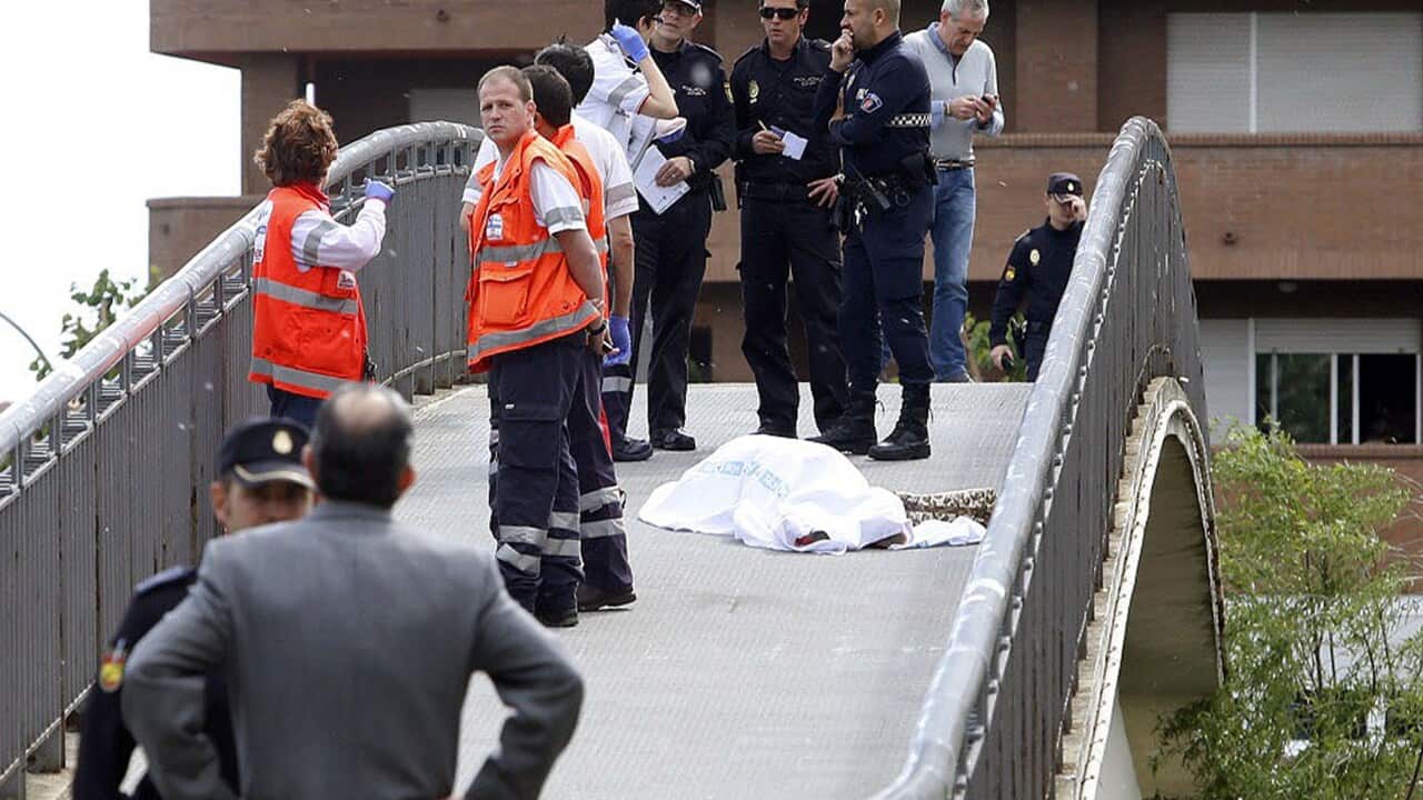 Police officers and rescue workers stand next to the covered body of a Spanish ruling party politician Isabel Carrasco in Leon on May 12, 2014. (AFP)