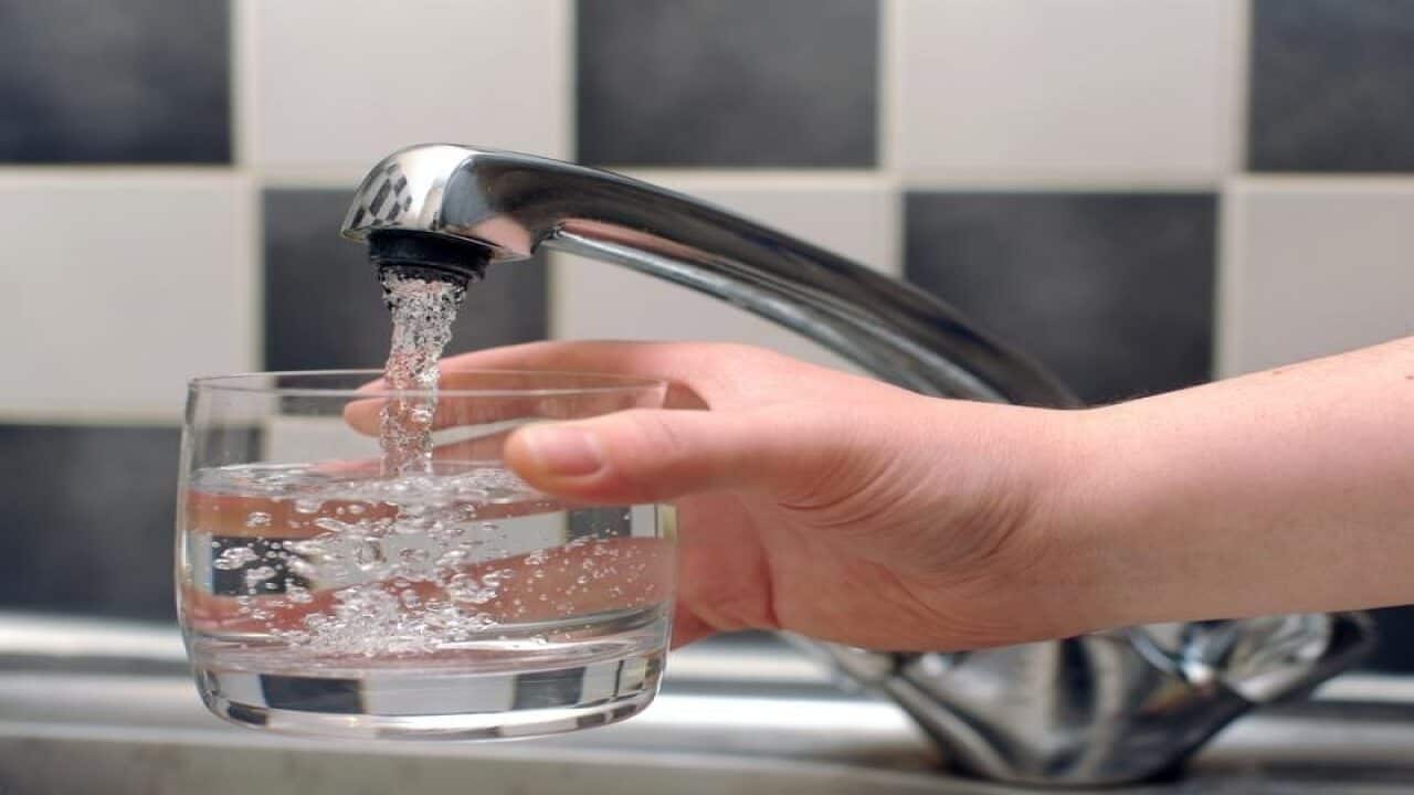 Tap water being poured from a tap in to a glass.