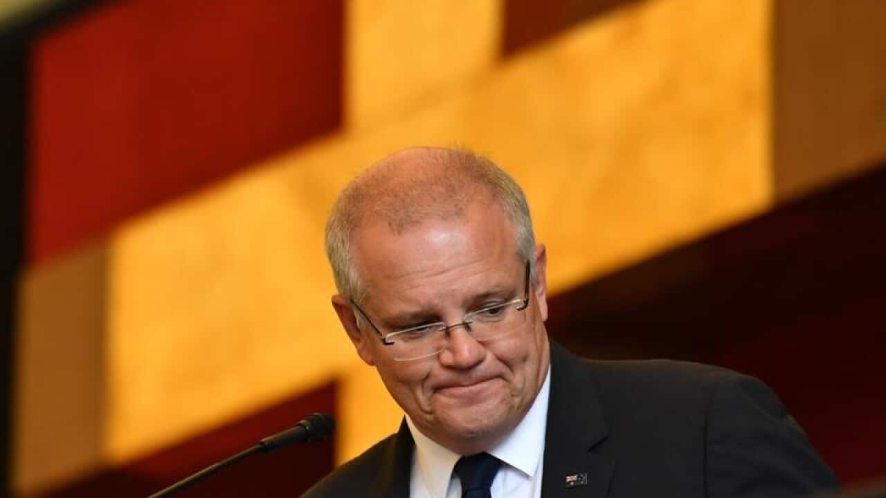 r Scott Morrison performs a reading during Good Friday service.