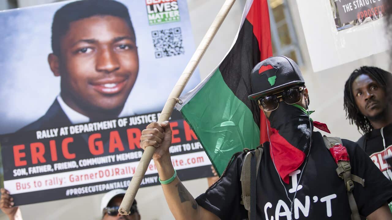 A man covers his face as he wears a shirt with Eric Garner's last words during a Black Lives Matter protest.