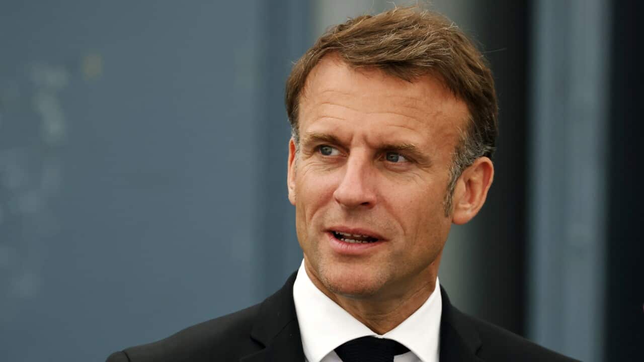 Emmanuel Macron wearing a black suit