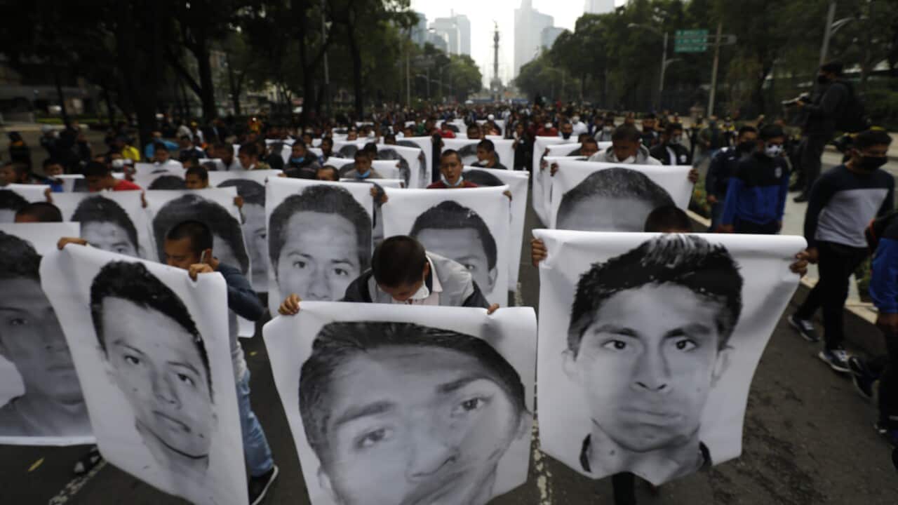 College students hold images of the 43 missing students in a march Mexico City to mark the sixth anniversary of their disappearance.