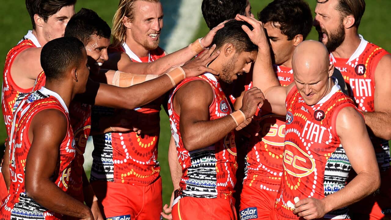 Suns player Aaron Hall (centre) celebrates with players
