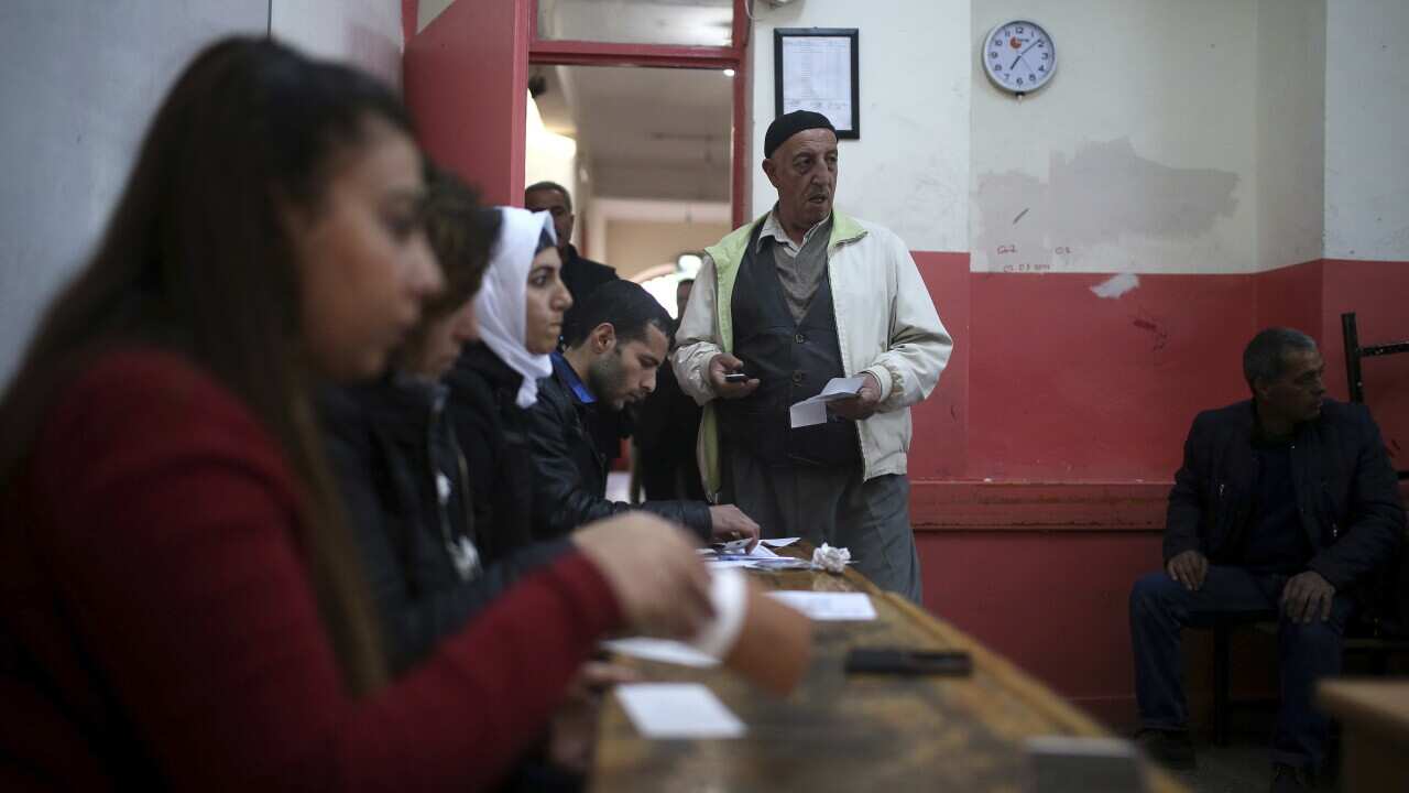 A voter stands in front of an electoral committee inside a polling station in Diyarbakir, southeastern Turkey.