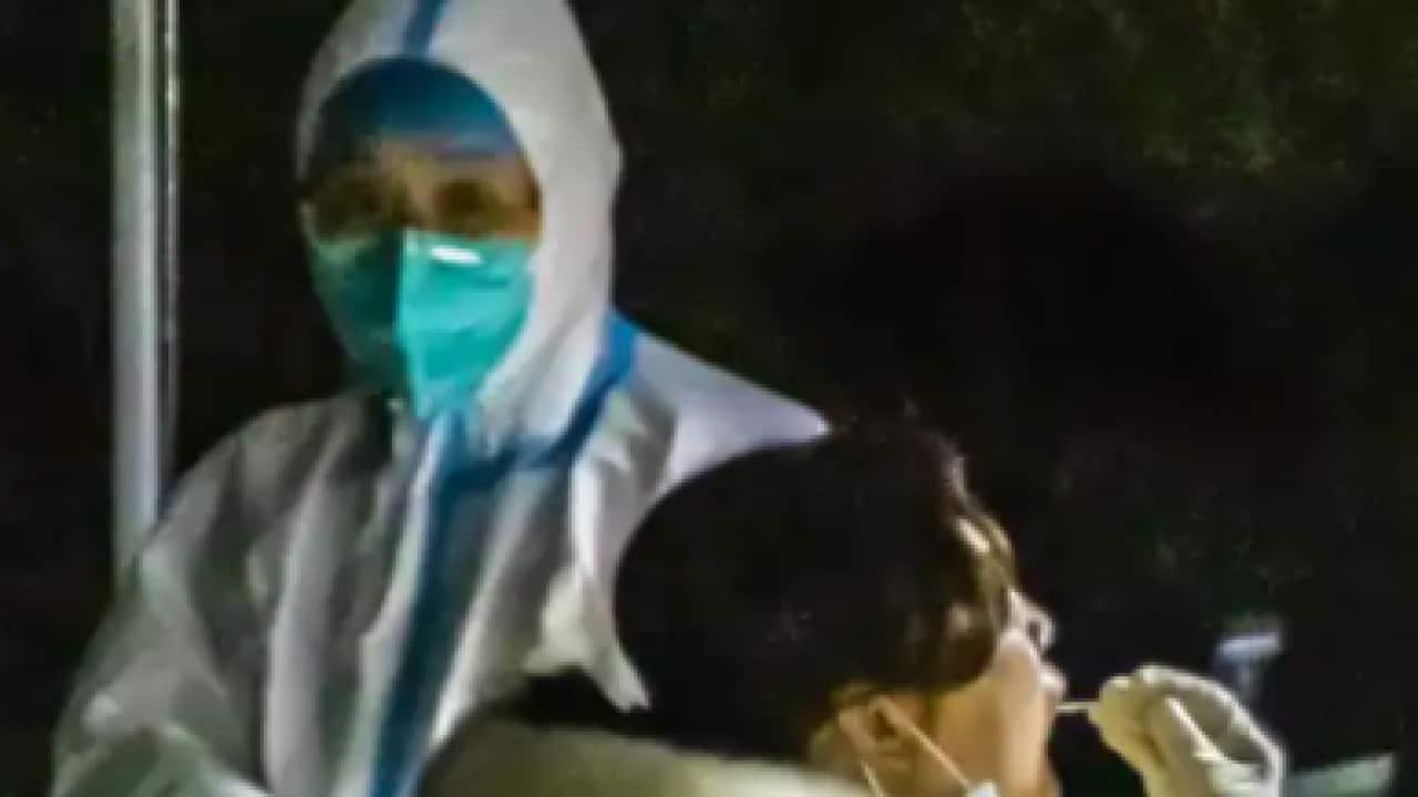 A medical worker takes a sample for a COVID-19 test at a testing site in Taizhou, east China's Jiangsu Province, on 30 March 30, 2022.