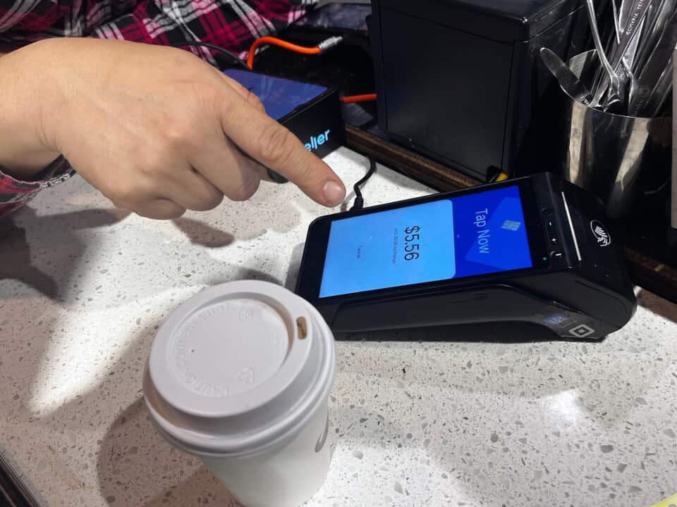 An eftpos terminal and coffee cup.
