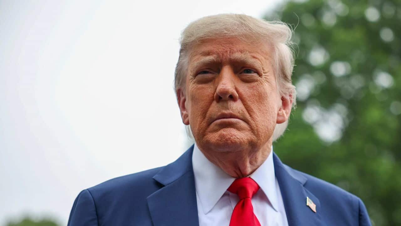 Donald Trump standing looking serious