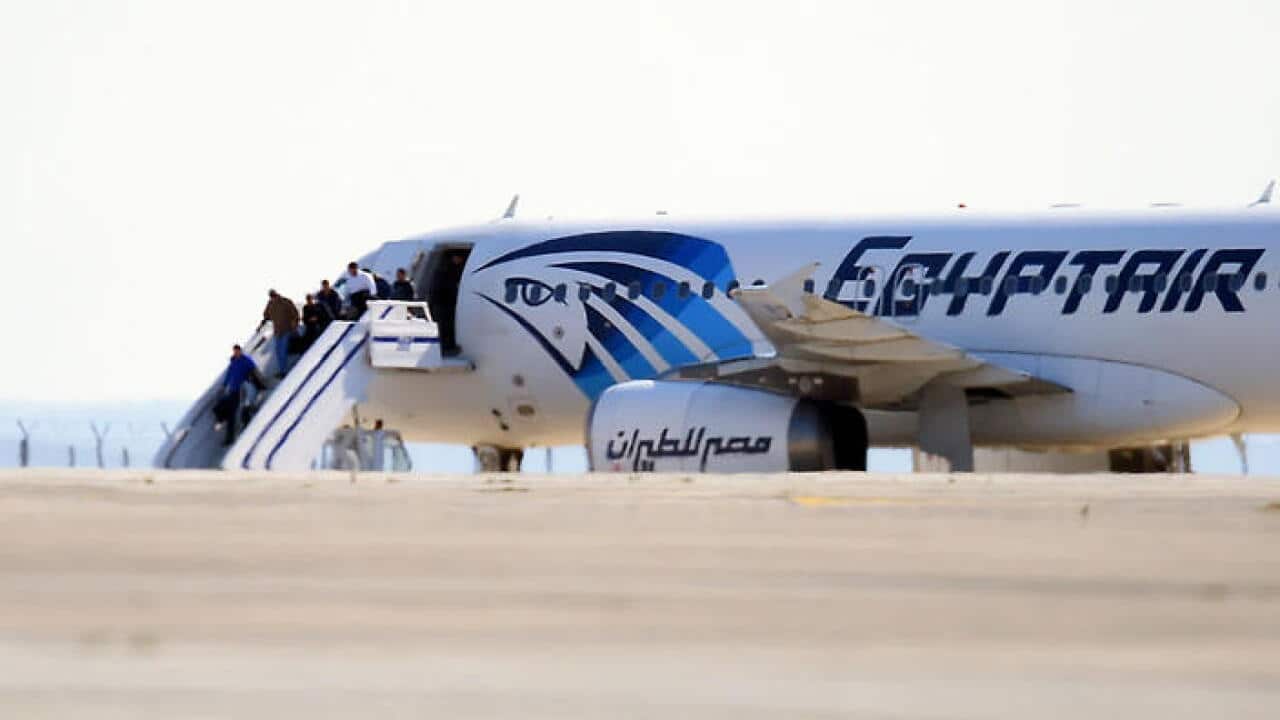 Passengers leave an EgyptAir Airbus A-320 sitting on the tarmac of Larnaca airport after it was hijacked and diverted to Cyprus on March 29, 2016. A hijacker seized the Egyptian airliner and diverted it to Cyprus, before releasing all the passengers excep