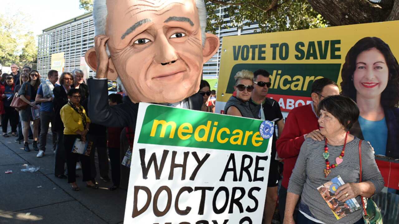 A protester wearing a giant puppet head depicting Malcolm Turnbull