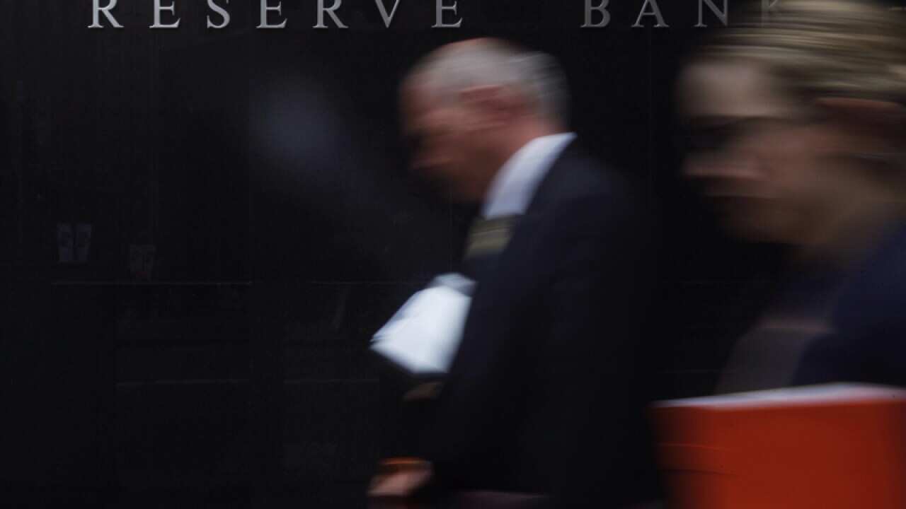 Pedestrians walk past the Reserve Bank of Australia head office