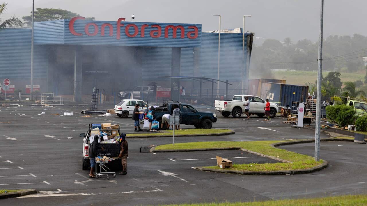 Looters packing groceries into cars in a car park