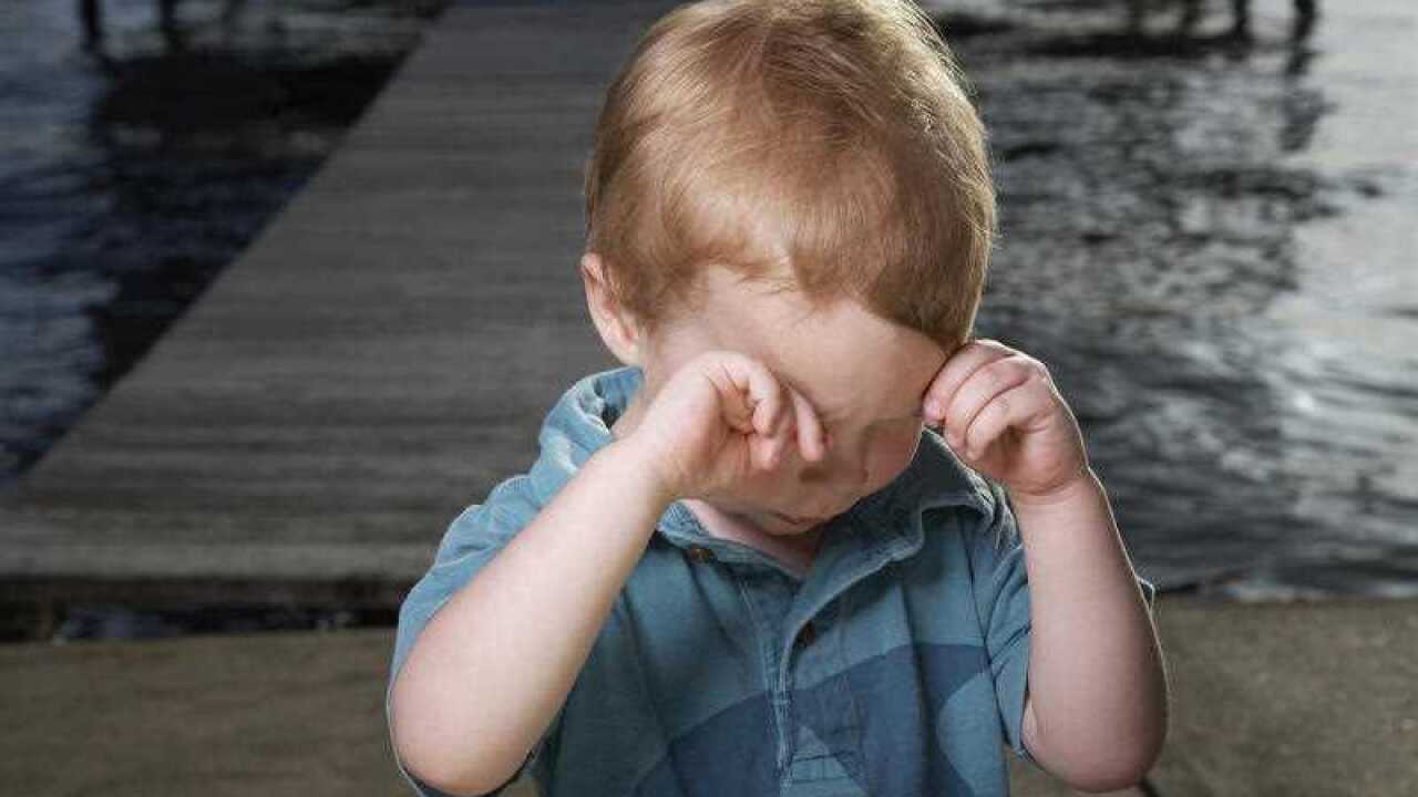 Little Boy on Pier Rubbing His Eyes
