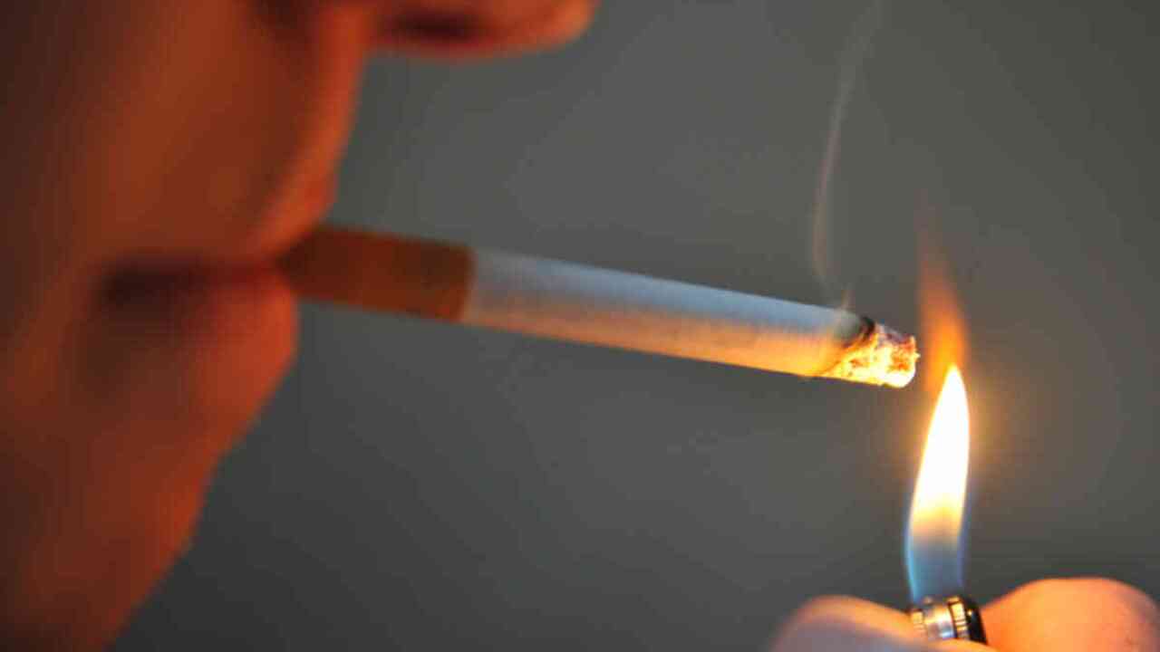 A man seen lighting a cigarette in Sydney, Sunday, Sept. 16, 2012. (AAP Image/Joel Carrett) NO ARCHIVING
