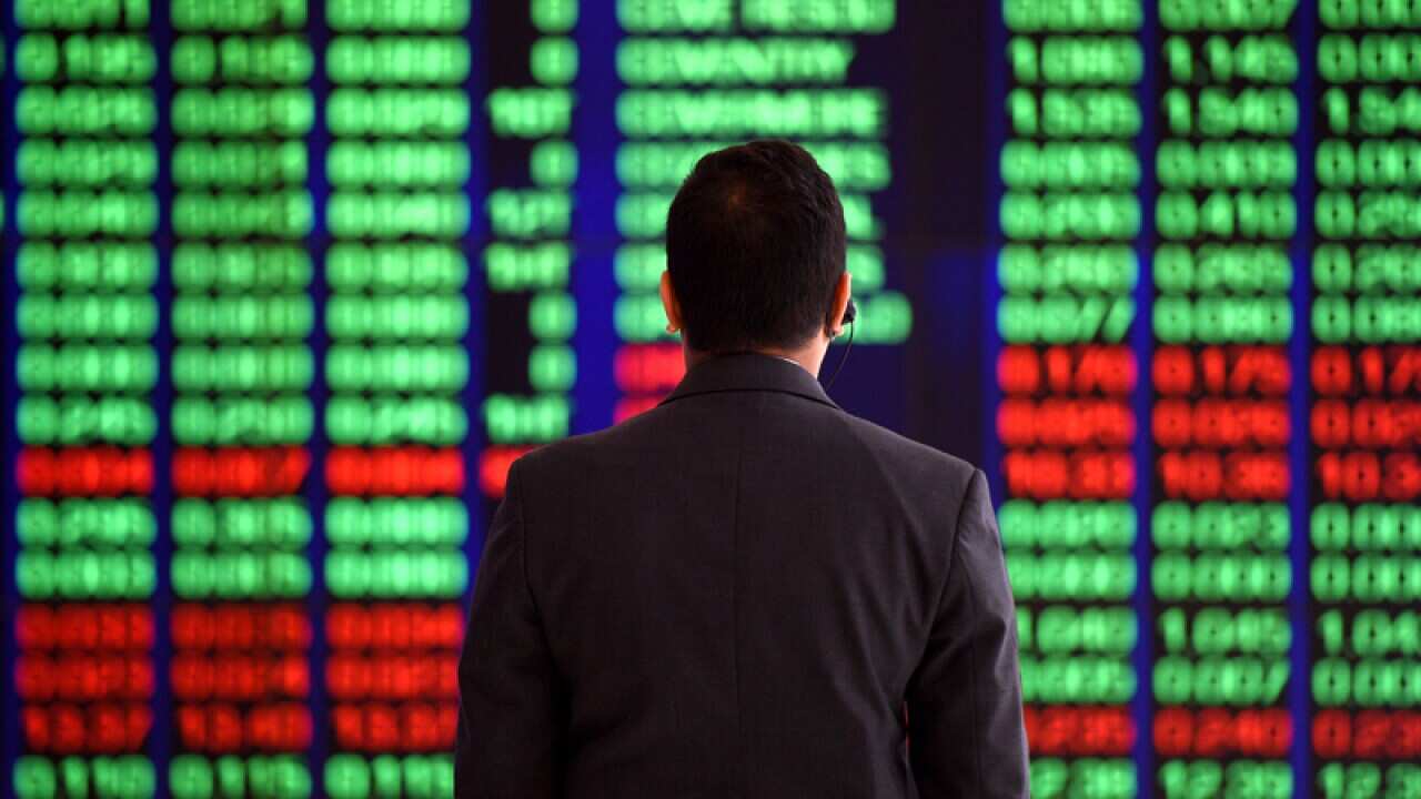 An attendant watches market gains at the ASX trading board in Sydney