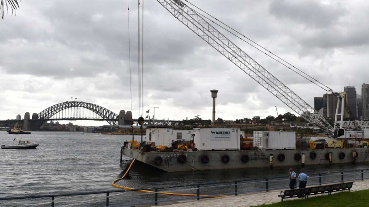 The barge and crane at Balmain East where a young man died swimming.