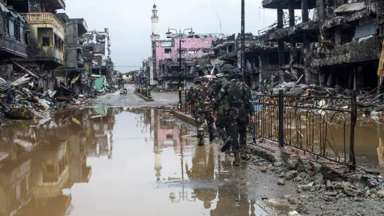 Filipino soldiers conduct patrol next to bombed-out buildings in the ruined city of Marawi, southern Philippines.
