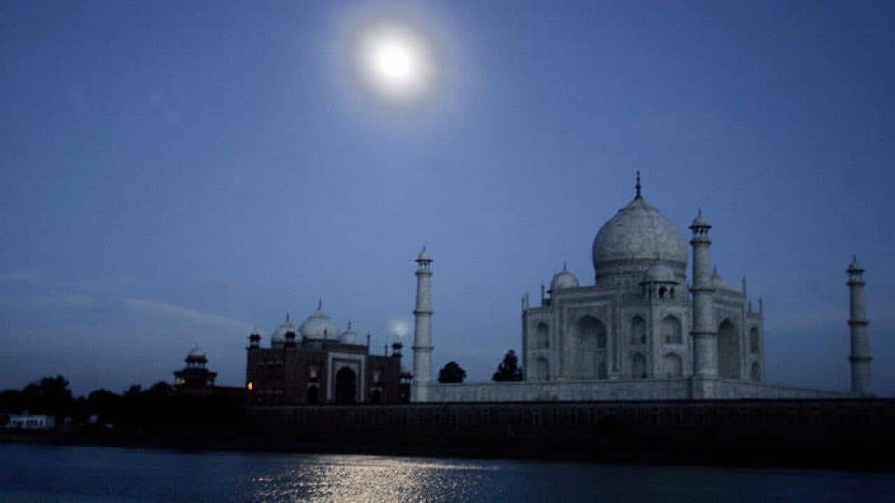 he moon is reflected in the River Yamuna as it flows past The Taj Mahal in Agra.