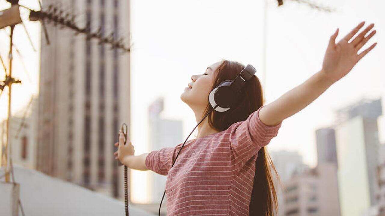 Young lady enjoying listening to music at rooftop
