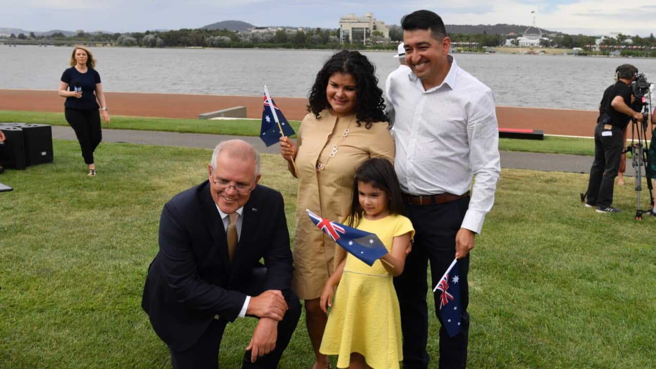 Prime Minister Scott Morrison poses for a photo with new citizens during an Australia Day Citizenship Ceremony and Flag Raising event in Canberra۔