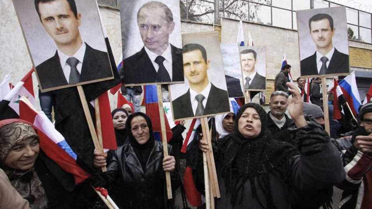 Syrians hold posters of Syrian President Bashar Assad, far left, and Russian President Vladimir Putin, second left, during a pro-Syrian goverment protest in front of the Russian Embassy in Damascus, Syria.(AAP)