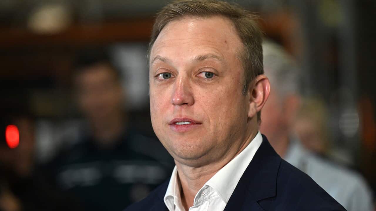 A man (Steven Miles) looks to the left while wearing a white collared shirt and jacket.