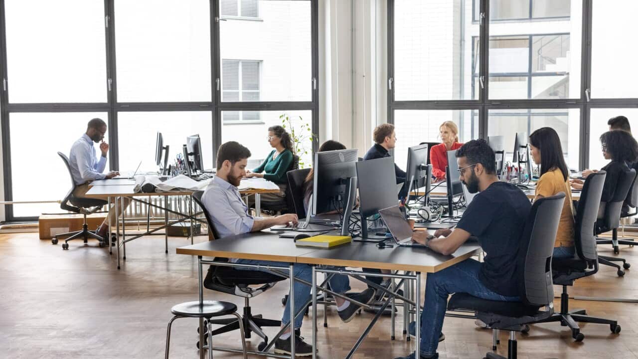 Open plan coworking office with business people at workstations