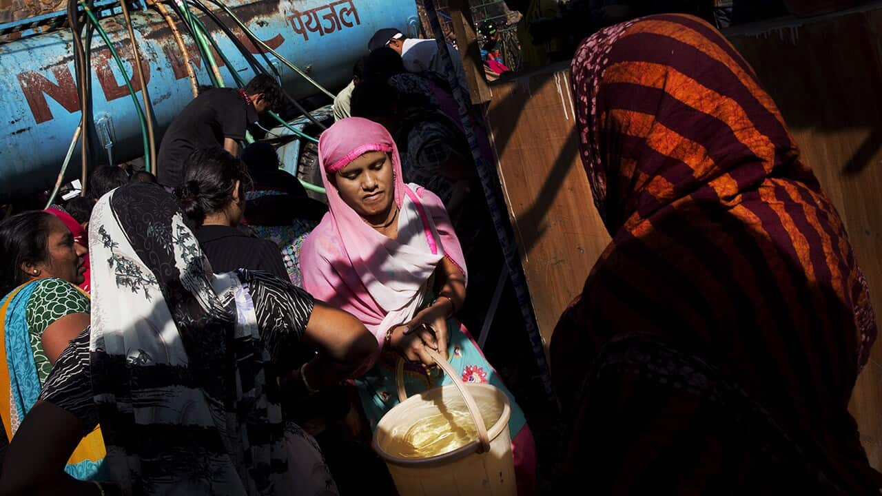 A woman carries a plastic container
