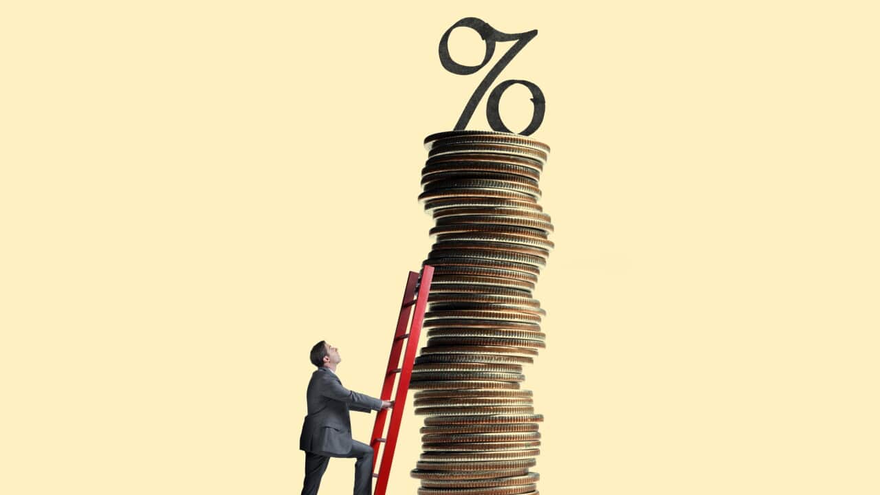 Man Leans Ladder Against Tall Stack Of Coins Topped With Interest Rate Symbol