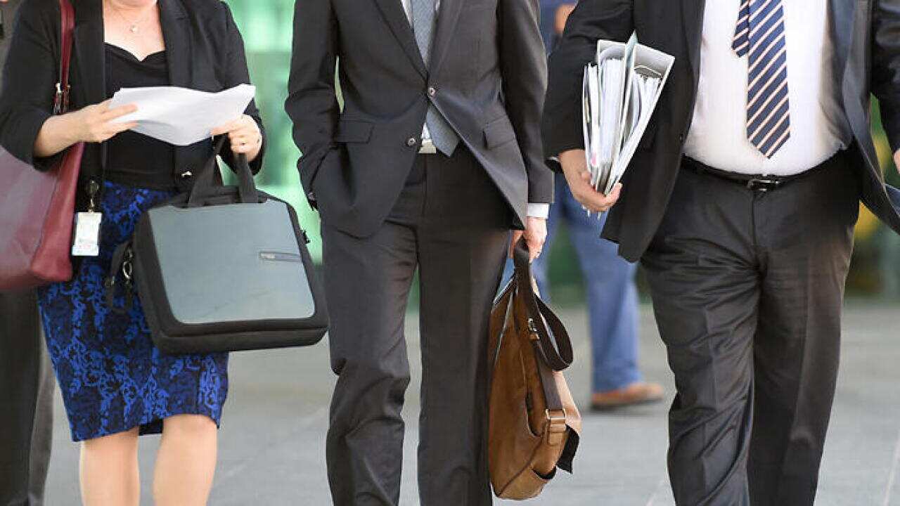 Office workers walk through central Brisbane, Wednesday, May 6, 2015. (AAP Image/Dave Hunt) NO ARCHIVING.