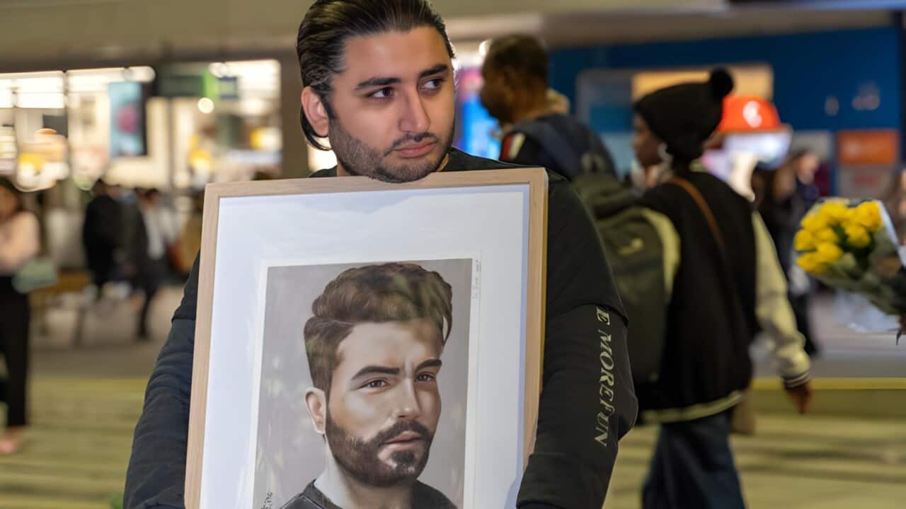 Mohammed Hashemi with a portrait of his cousin Majid Kazemi (Supplied).jpg
