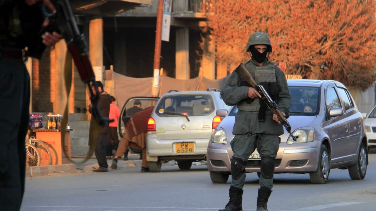 Afghan security officials stand guard on a road side check point on the outskirts of Ghazni, Afghanistan, 18 December 2020.
