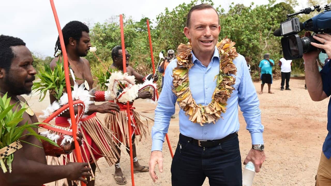 A traditional farewell is given to Prime minister Tony Abbott as he visits the grave of land rights activist Eddie Mabo.