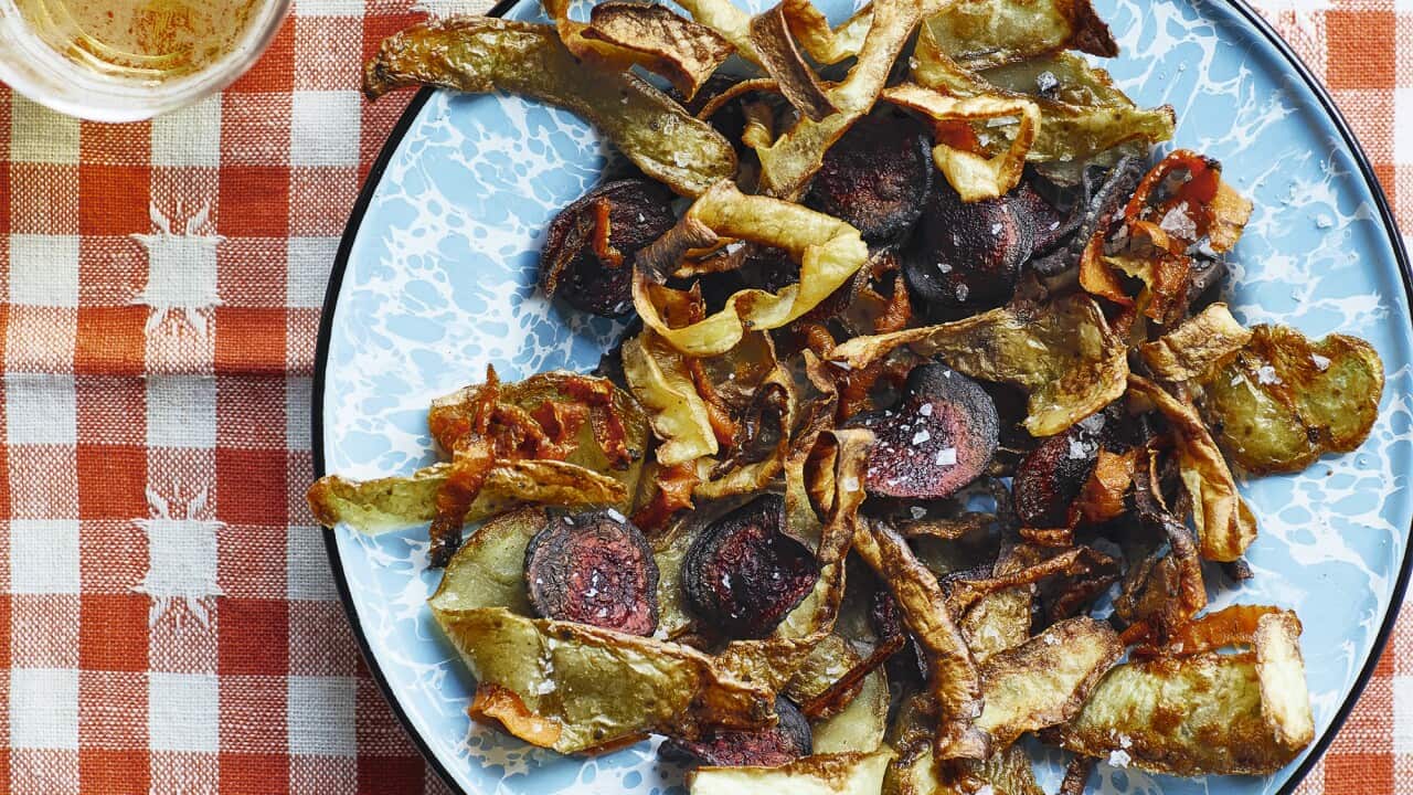 A plate of variously coloured vegetable crisps sit on a blue plate.