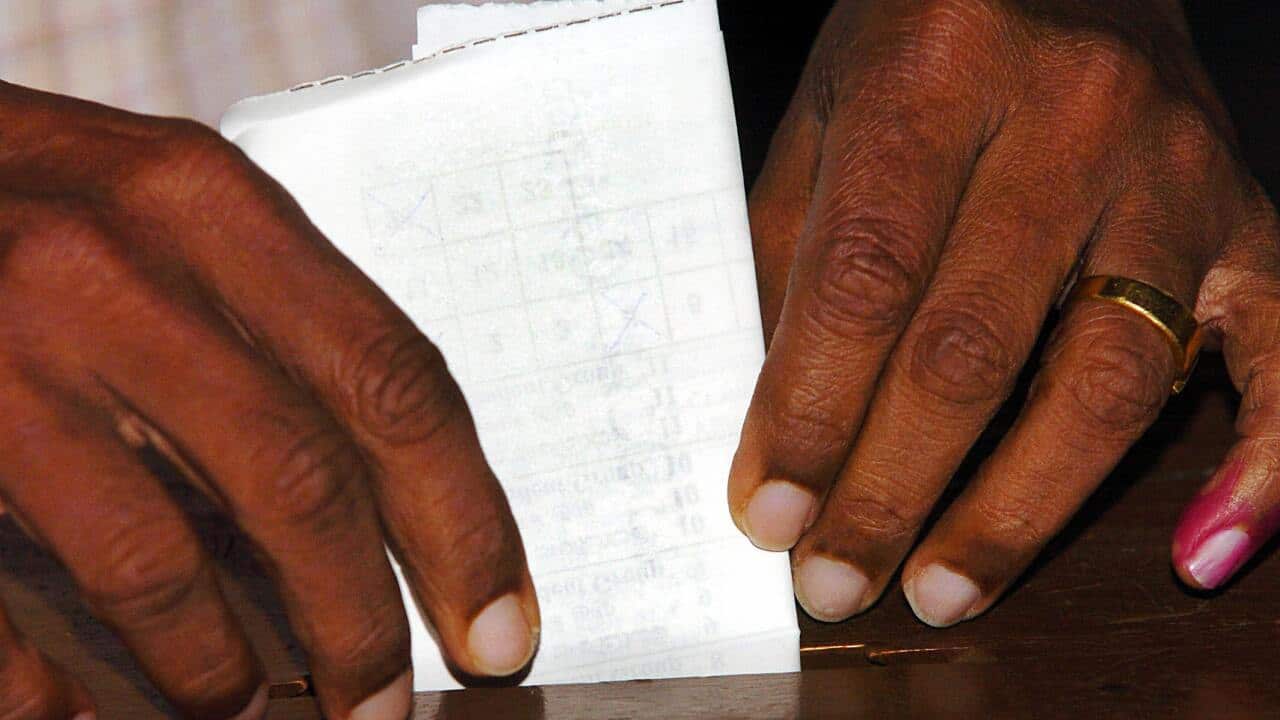 A Sri Lankan voter inserts his ballot pa