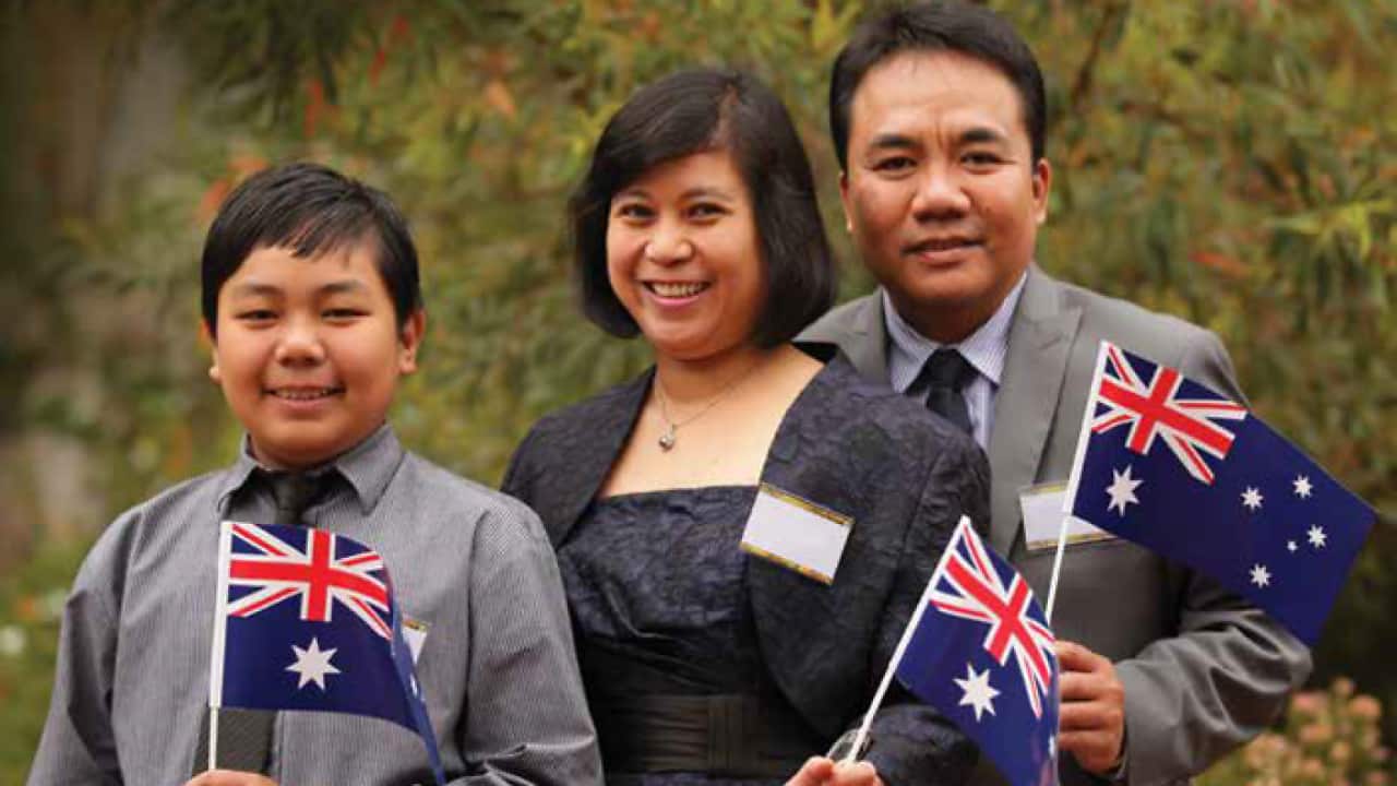 An image of a family holding Australian flags used by the government in its discussion paper around citizenship changes.