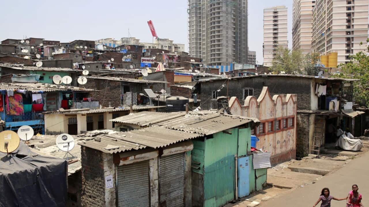 Girls cycle through a shanty town in Mumbai, India